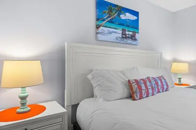 a bedroom with a bed with a lamp on a night stand at Family Escape! HotTub+Grill+Disney! in Kissimmee