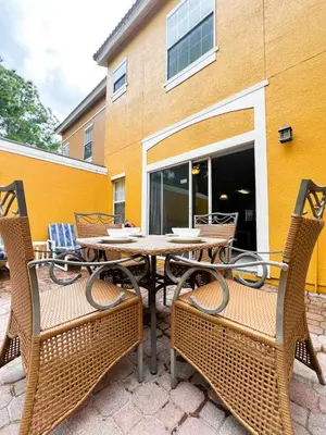 a patio with a table and chairs and a building at Hot Tub, BBQ - Near Disney Fun! in Kissimmee