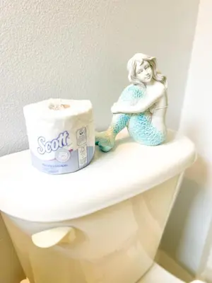 a figurine of a mermaid sitting on top of a toilet at Hot Tub, BBQ - Near Disney Fun! in Kissimmee