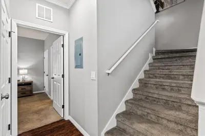 a staircase in a home with white walls and a stair case at Luxury 4BR Resort Villa @ Lucaya Village in Kissimmee