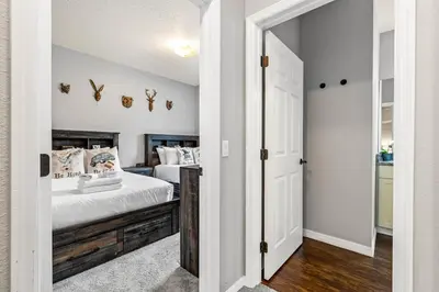 a bedroom with two beds with white walls and a doorway at Luxury 4BR Resort Villa @ Lucaya Village in Kissimmee