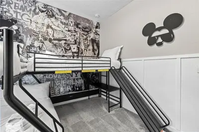 a bedroom with a bunk bed with a wall covered in graffiti at Luxury 4BR Resort Villa @ Lucaya Village in Kissimmee