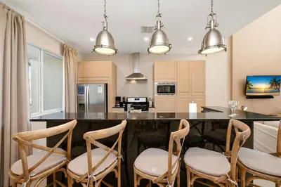 a kitchen with a bar with chairs around it at Two Story Resort Retreat Near Theme Parks in Orlando