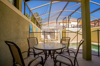 a table and chairs on a balcony with a glass roof at Paradise Found: Private 5-Bed Townhouse Oasis in Kissimmee