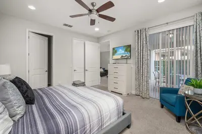 a bedroom with a bed and a ceiling fan at Private Heated Pool Game room 6MI to Disney in Orlando