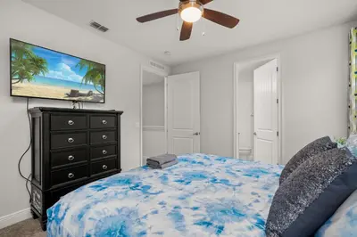 a bedroom with a bed and a ceiling fan at Private Heated Pool Game room 6MI to Disney in Orlando
