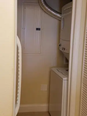 a small laundry room with a washer and dryer at Blue Heron Beach Resort Tower 12 FL 1204 Fully Furnished in Orlando