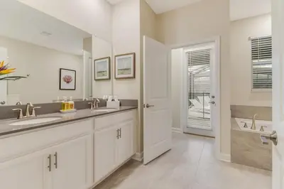 a white bathroom with two sinks and a mirror at Your Beautiful Hideaway 9-Bedroom Luxury Villa in Kissimmee