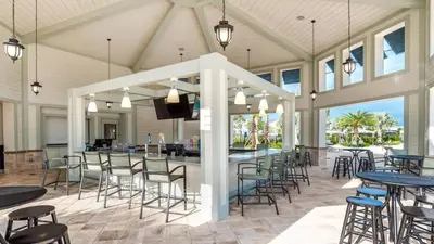 a covered patio with tables and chairs and a bar at Your Beautiful Hideaway 9-Bedroom Luxury Villa in Kissimmee