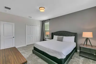 a bedroom with a large bed and a table at Casa 6Q c/ Piscina & Sala de Jogos — Storey Lake in Kissimmee