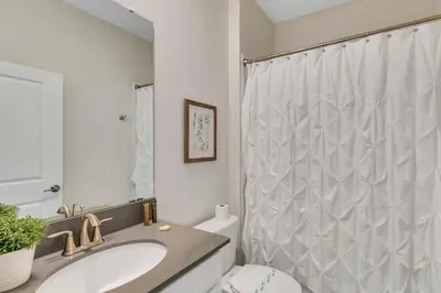 a bathroom with a sink and a shower curtain at Casa 6Q c/ Piscina & Sala de Jogos — Storey Lake in Kissimmee