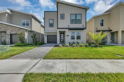 a house with a driveway and grass at Casa 6Q c/ Piscina & Sala de Jogos — Storey Lake in Kissimmee