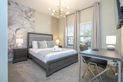 a bedroom with a bed and a desk and a desk at Townhome 5Q c/ Piscina – 8mi da Disney in Kissimmee