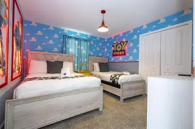 a bedroom with two beds and a toy story sign on the wall at Townhome 5Q c/ Piscina – 8mi da Disney in Kissimmee
