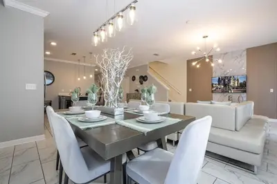 a dining room with a table and white chairs at Townhome 5Q c/ Piscina – 8mi da Disney in Kissimmee