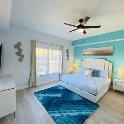 a bedroom with a bed and a blue wall at Your Epic Disney Getaway Spacious Home 3BD 3BA in Orlando