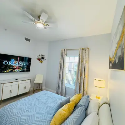 a bedroom with a couch and a tv on the wall at Your Epic Disney Getaway Spacious Home 3BD 3BA in Orlando