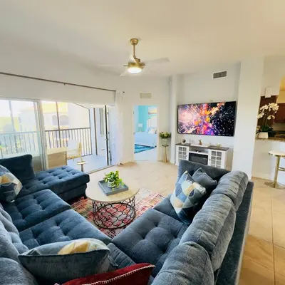 a living room with a blue couch and a table at Your Epic Disney Getaway Spacious Home 3BD 3BA in Orlando