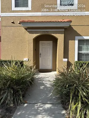 a building with a white door and some plants at Cosy Family Home in encantada kissimee in Kissimmee