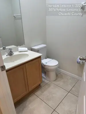 a bathroom with a toilet and a sink and a mirror at Cosy Family Home in encantada kissimee in Kissimmee