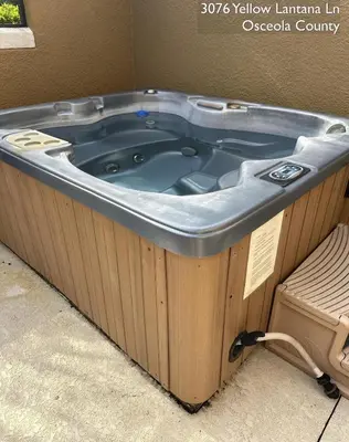 a jacuzzi tub in a room with a bench at Cosy Family Home in encantada kissimee in Kissimmee