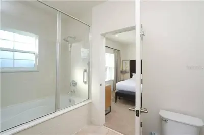 a bathroom with a shower and a toilet and a bed at Casa 3Q no Regal Oaks Resort, Perto da Disney in Orlando
