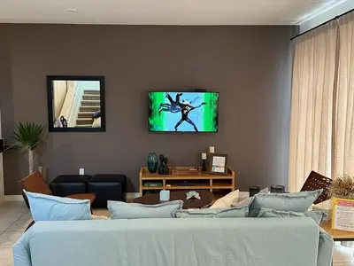 a living room with a bed and a tv on the wall at Casa 3Q no Regal Oaks Resort, Perto da Disney in Orlando