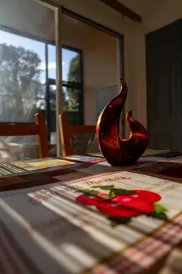 a vase sitting on a table with a red rose at Mango Keys Getaway Near Theme Parks in Kissimmee