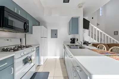 a white kitchen with a sink and a stove at Mango Keys Getaway Near Theme Parks in Kissimmee