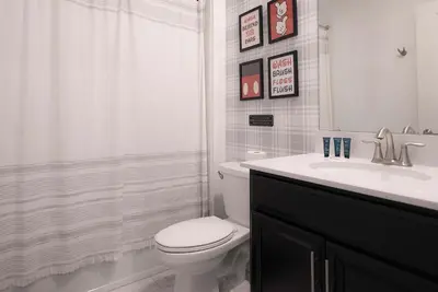 a white bathroom with a toilet and a sink at Casa 5Q Storey Lake Resort c/ Piscina Privada in Kissimmee