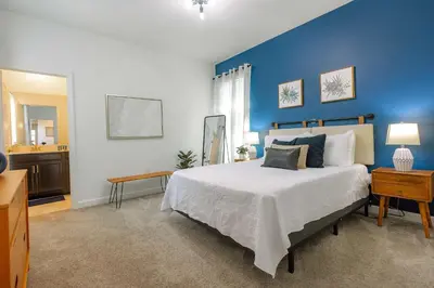 a bedroom with a large bed with a blue wall at Casa 5Q Storey Lake Resort c/ Piscina Privada in Kissimmee