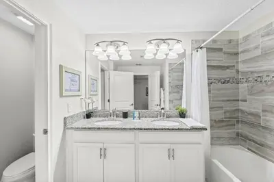 a bathroom with two sinks and a tub and a mirror at Casa c/ 4Q no Storey Lake Resort c/ Piscina in Kissimmee