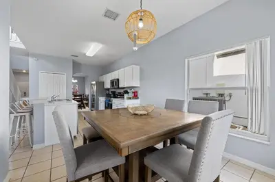a kitchen and dining room with a wooden table and chairs at Water View Pool Home Near Disney in Kissimmee