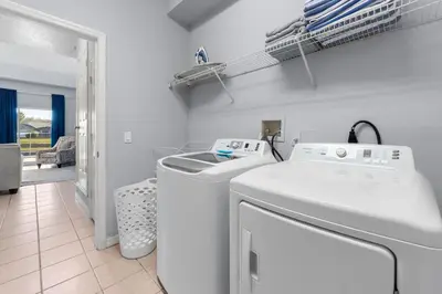 a white laundry room with a washer and dryer at Water View Pool Home Near Disney in Kissimmee