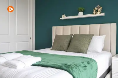 a bed with green and white sheets and pillows at 7547 NEW 5 minutes from Disney 5BD 5BH 15P in Orlando