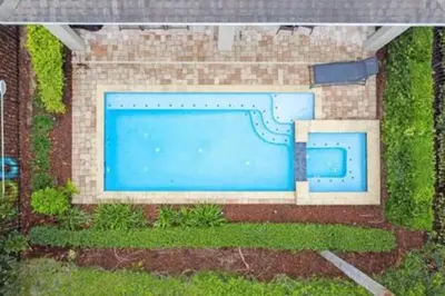 a large blue swimming pool in a brick building at 381 Fantastic Home Near Disney 5BD 5BT 14P in Orlando