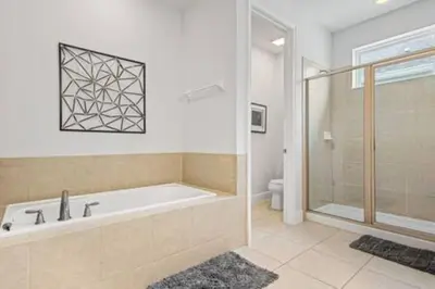 a bathroom with a bath tub and a shower at 381 Fantastic Home Near Disney 5BD 5BT 14P in Orlando