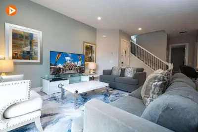 a living room with a couch and a tv at Perfect Home 5 Minutes from Disney 5BD 15P in Orlando