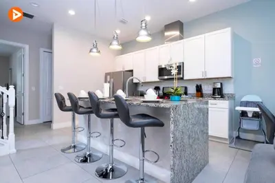 a kitchen with a bar with stools at a counter at Perfect Home 5 Minutes from Disney 5BD 15P in Orlando