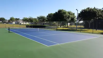 a tennis court with a net on top of it at 20 mins Disney, Private Heated Pool & Spa, Games Room, Spacious, Good for Groups in Orlando
