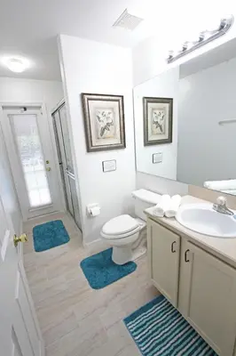 a bathroom with a toilet and a sink and a mirror at 20 mins Disney, Private Heated Pool & Spa, Games Room, Spacious, Good for Groups in Orlando