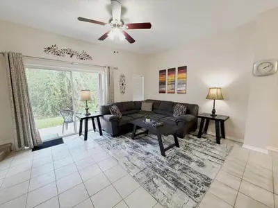 a living room with a couch and a ceiling fan at The Family Den in Kissimmee