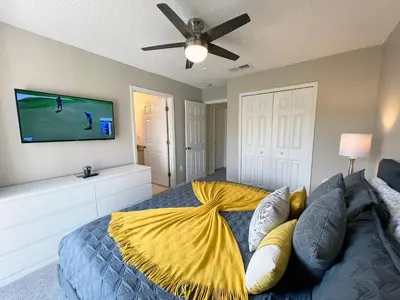 a bedroom with a bed with a yellow blanket on it at Sun Key Getaway in Kissimmee