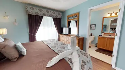 a bedroom with a large bed and a bathroom at Magari at Emerald Island in Kissimmee