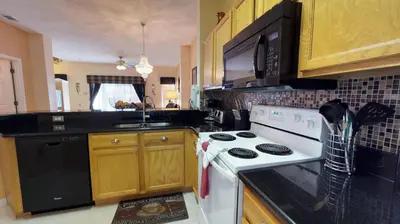 a kitchen with a white stove and a sink at Magari at Emerald Island in Kissimmee