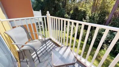 a white balcony with a chair and a window at Magari at Emerald Island in Kissimmee