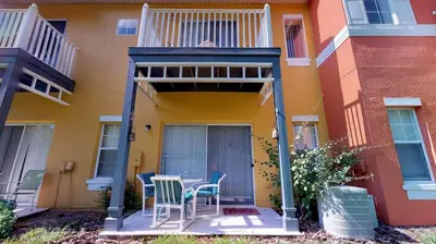 a patio with chairs and a table in front of a house at Magari at Emerald Island in Kissimmee