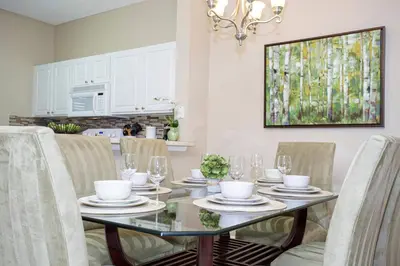 a dining room with a glass table and chairs at Americana at Emerald Island in Kissimmee