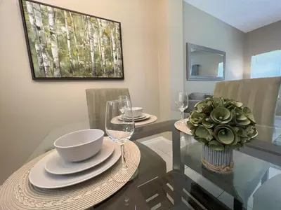 a dining room with a table with plates and glasses at Americana at Emerald Island in Kissimmee