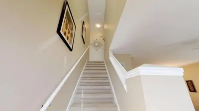a stairway with white walls and white stairs at Americana at Emerald Island in Kissimmee